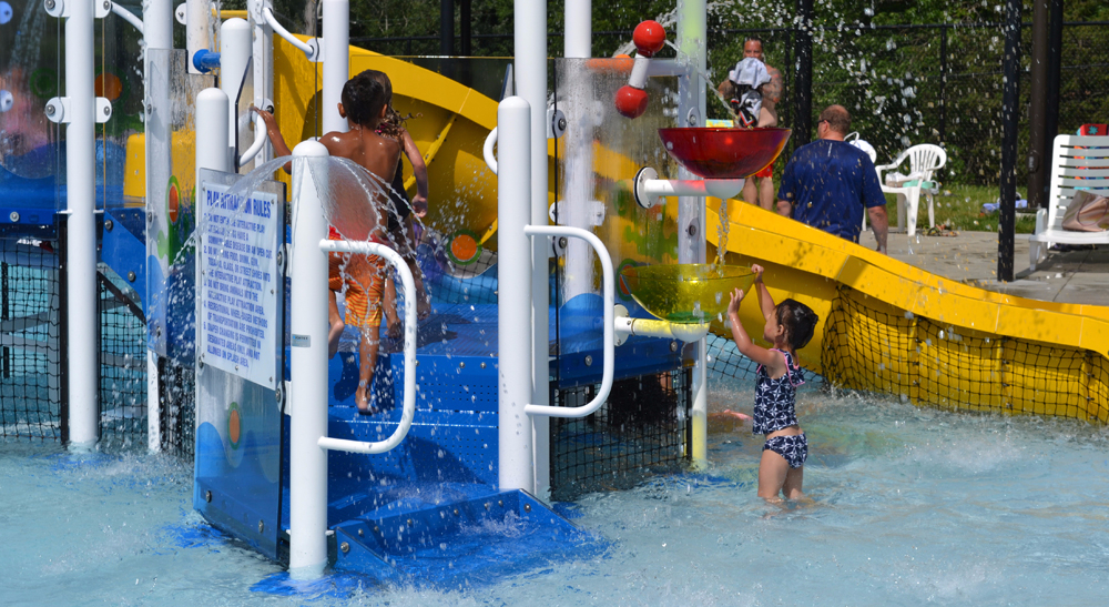 Kids playing on the Schulenburg Pool's giant play structure in the leisure area